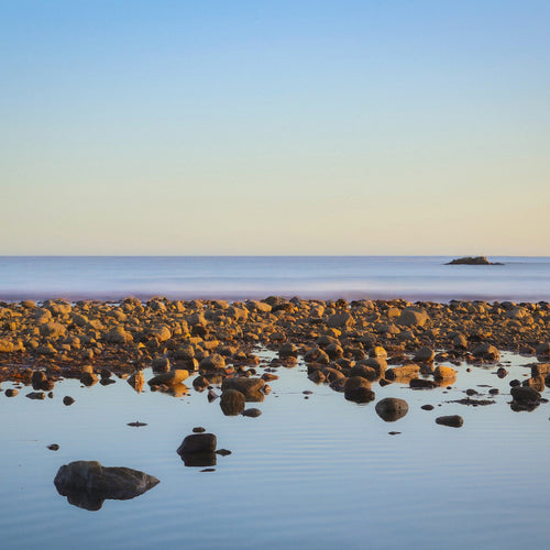 Rocks on a beach with a clear sky
