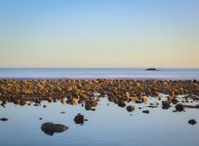 Rocks on a beach with a clear sky