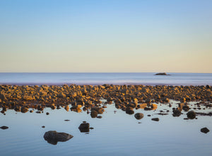 Rocks on a beach with a clear sky