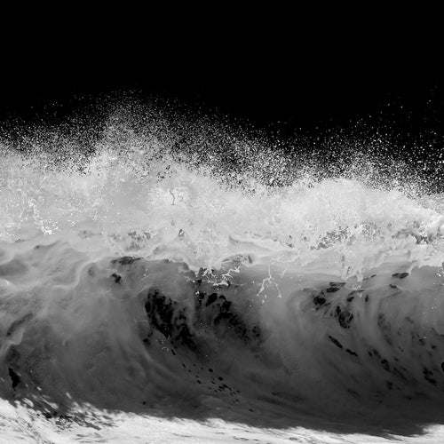 Black and white photo of a large wave crashing.