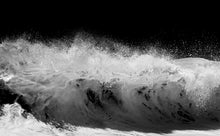Black and white photo of a large wave crashing.