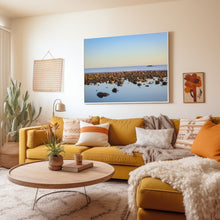 Living room with yellow sofa, decorative pillows, and a large wall art of a beach scene.