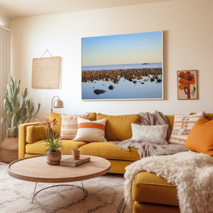 Living room with yellow sofa, decorative pillows, and a large wall art of a beach scene.