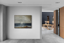 Modern interior with a framed artwork on a wall, leading to a dining area.